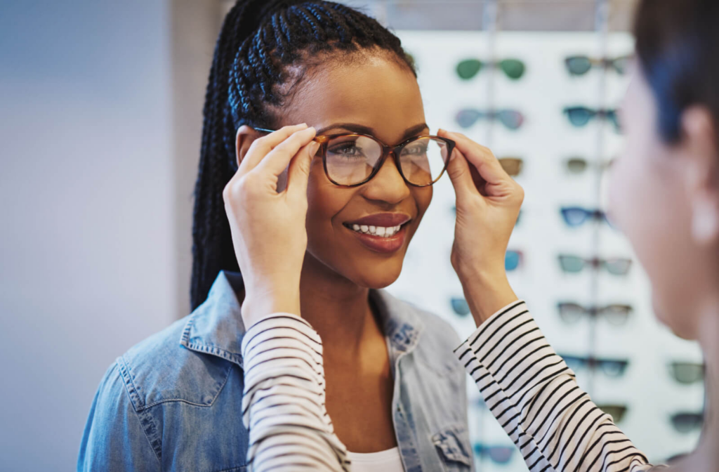 A woman at her optometrist in Mississauga, getting a personalized glasses fitting from an optician